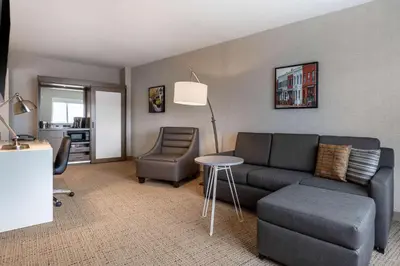 a living room with a couch and a chair at Cambria Hotel West Orange in West Orange