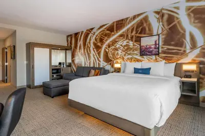 a hotel room with a bed and a couch at Cambria Hotel West Orange in West Orange