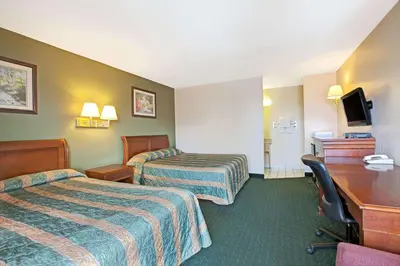 a hotel room with two beds and a desk at Knights Inn South Hackensasck in South Hackensack