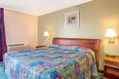 a hotel room with a bed with a colorful bedspread at Knights Inn South Hackensasck in South Hackensack