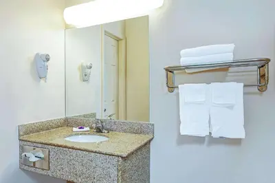 a bathroom with a sink and a mirror and towels at Knights Inn South Hackensasck in South Hackensack