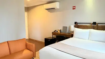 a bedroom with a bed and a chair and a desk at Madison LES Hotel in New York