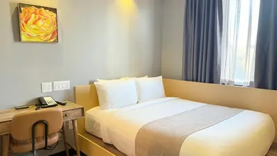 a hotel room with a bed and a desk with a phone at Madison LES Hotel in New York
