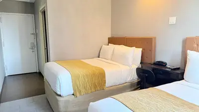 a hotel room with two beds and a desk at Madison LES Hotel in New York