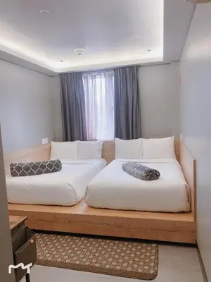 two beds sitting on a wooden platform in a room at Madison LES Hotel in New York