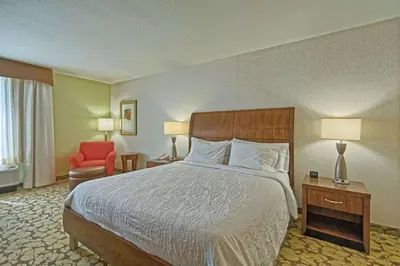 a hotel room with a bed and a red chair at Hilton Garden Inn by Hilton Mount Laurel in Mount Laurel