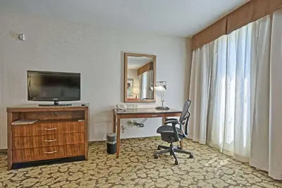 a hotel room with a desk with a television and a chair at Hilton Garden Inn by Hilton Mount Laurel in Mount Laurel