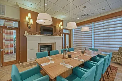 a dining room with a table and chairs and a fireplace at Hilton Garden Inn by Hilton Mount Laurel in Mount Laurel