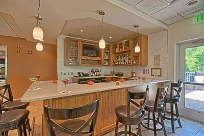 a kitchen with a bar with chairs around it at Hilton Garden Inn by Hilton Mount Laurel in Mount Laurel