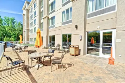 a patio with tables and chairs and a building at Hilton Garden Inn by Hilton Mount Laurel in Mount Laurel