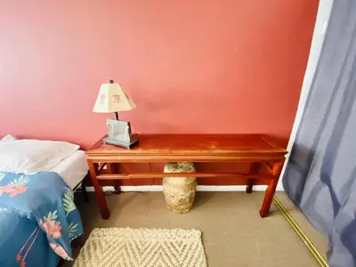 a table with a lamp on it next to a bed at Airport Xpress Guestrooms in Philadelphia