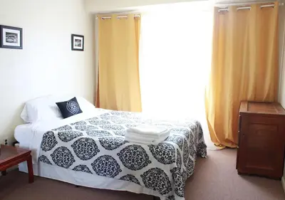 a bedroom with a bed and a large window at Airport Xpress Guestrooms in Philadelphia