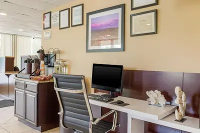 an office with a desk with a computer and a chair at Fairmount Inn & Suites - Stroudsburg, Poconos in Delaware Water Gap