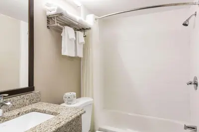 a bathroom with a tub and a sink and a toilet at Fairmount Inn & Suites - Stroudsburg, Poconos in Delaware Water Gap