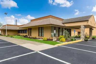 a building with a parking lot in front of it at Fairmount Inn & Suites - Stroudsburg, Poconos in Delaware Water Gap