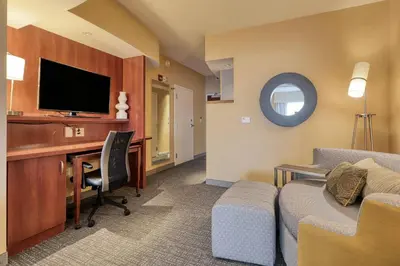 a hotel room with a desk and a tv at Courtyard by Marriott York in York