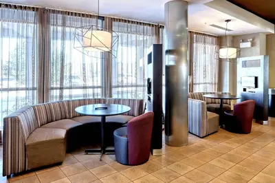 a lobby with a couch and tables and windows at Courtyard by Marriott York in York