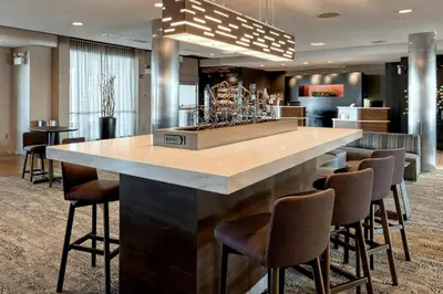 a large kitchen with a large island with bar chairs at Courtyard by Marriott York in York