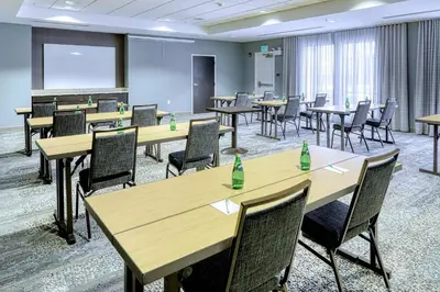 a conference room with tables and chairs and a screen at Courtyard by Marriott York in York