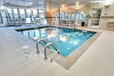 a pool in a hotel with chairs and tables at Courtyard by Marriott York in York