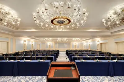 a large banquet hall with blue tables and a chandelier at Lotte New York Palace in New York