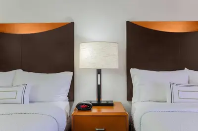 a hotel room with two beds and a table with a lamp at Fairfield Inn & Suites by Marriott Mahwah in Mahwah
