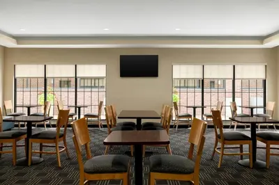 a room with tables and chairs and a flat screen tv at TownePlace Suites by Marriott Williamsport in Williamsport