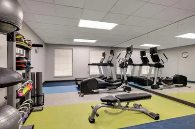 a gym with several treadmills and elliptical machines at TownePlace Suites by Marriott Williamsport in Williamsport