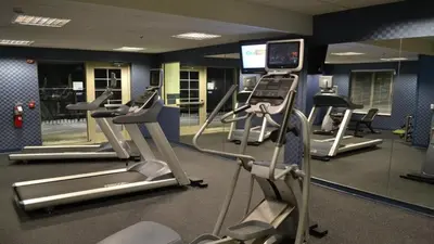 a gym with several tread machines and a mirror at Holiday Inn Express and Suites Dickson City by IHG in Dickson City