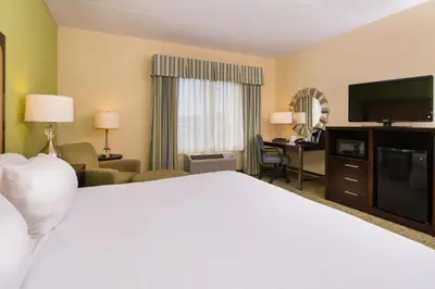 a hotel room with a white bed and a television at Holiday Inn Express and Suites Dickson City by IHG in Dickson City