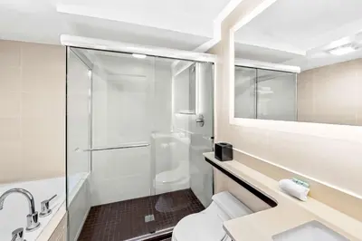 a bathroom with a shower and a toilet and a sink at Best Western Inn at Ramsey in Ramsey