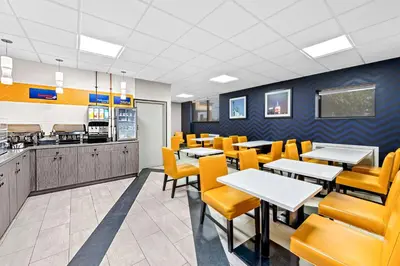 a dining room with tables and yellow chairs at Best Western Inn at Ramsey in Ramsey