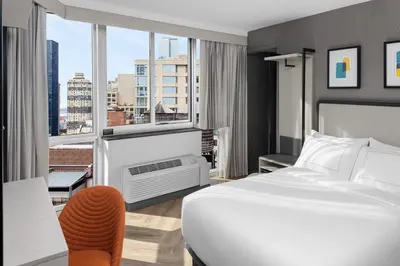a hotel room with a bed and a large window at voco Times Square South New York by IHG in New York