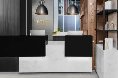 a lobby with two desks with laptops on them at voco Times Square South New York by IHG in New York
