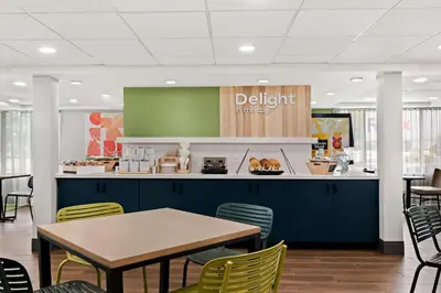 a dining area with a table and chairs in a cafeteria at Spark By Hilton Hummelstown Hershey in Hummelstown