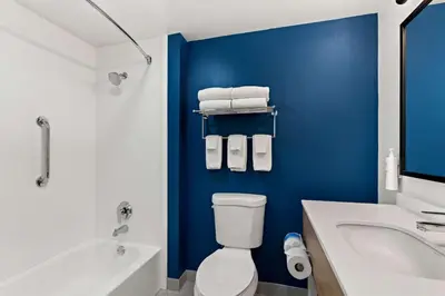 a bathroom with a white toilet and a blue wall at Spark By Hilton Hummelstown Hershey in Hummelstown