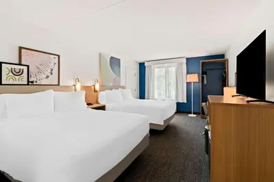 a hotel room with two beds and a flat screen tv at Spark By Hilton Hummelstown Hershey in Hummelstown