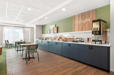 a kitchen with blue cabinets and a table and chairs at Spark By Hilton Hummelstown Hershey in Hummelstown