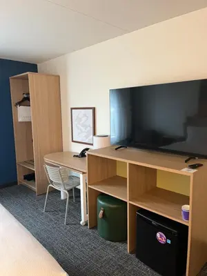 a room with a desk and a large screen tv at Spark By Hilton Hummelstown Hershey in Hummelstown