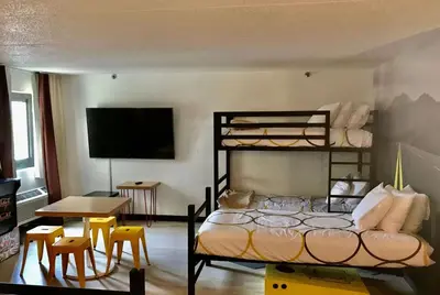 a bedroom with a bunk bed and a table and chairs at Super 8 by Wyndham Mahwah in Mahwah