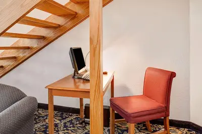 a desk with a computer and a red chair at Super 8 by Wyndham Mahwah in Mahwah