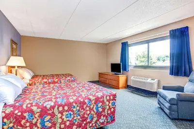 a hotel room with a bed and a chair and a window at Super 8 by Wyndham Mahwah in Mahwah