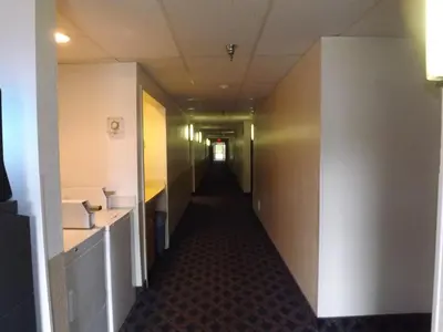 a hallway in an office building with a long corridor at Super 8 by Wyndham Sidney NY in Sidney