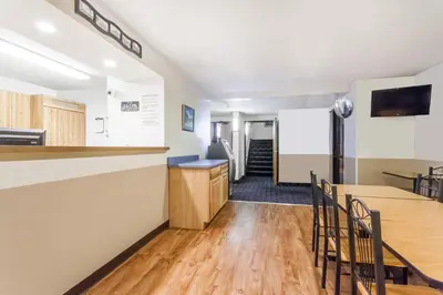 a kitchen and dining room with a counter and chairs at Super 8 by Wyndham Sidney NY in Sidney