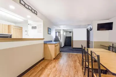 a kitchen and dining room with a counter and chairs at Super 8 by Wyndham Sidney NY in Sidney