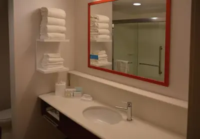 a bathroom with a sink and a mirror and towels at Hampton Inn & Suites Philadelphia/Media in Media