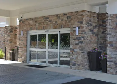 a brick building with sliding glass doors on it at Hampton Inn & Suites Philadelphia/Media in Media