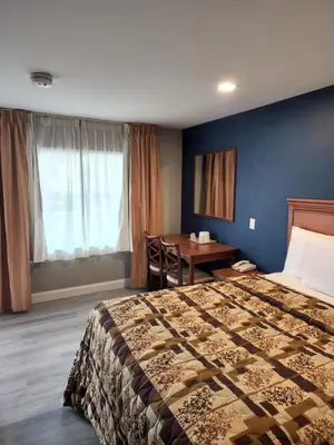 a hotel room with a bed and a desk at Budget Inn Horseheads in Horseheads