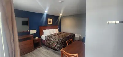 a hotel room with a bed and a mirror at Budget Inn Horseheads in Horseheads