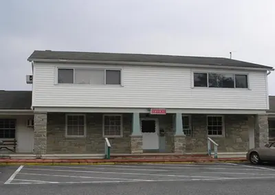 a building with a car parked in front of it at Red Carpet Inn & Suites Morgantown in Morgantown